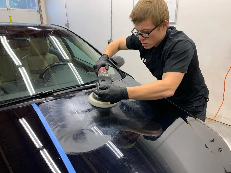 Machine polishing a vehicle hood during paint correction at Coastline Auto Detail