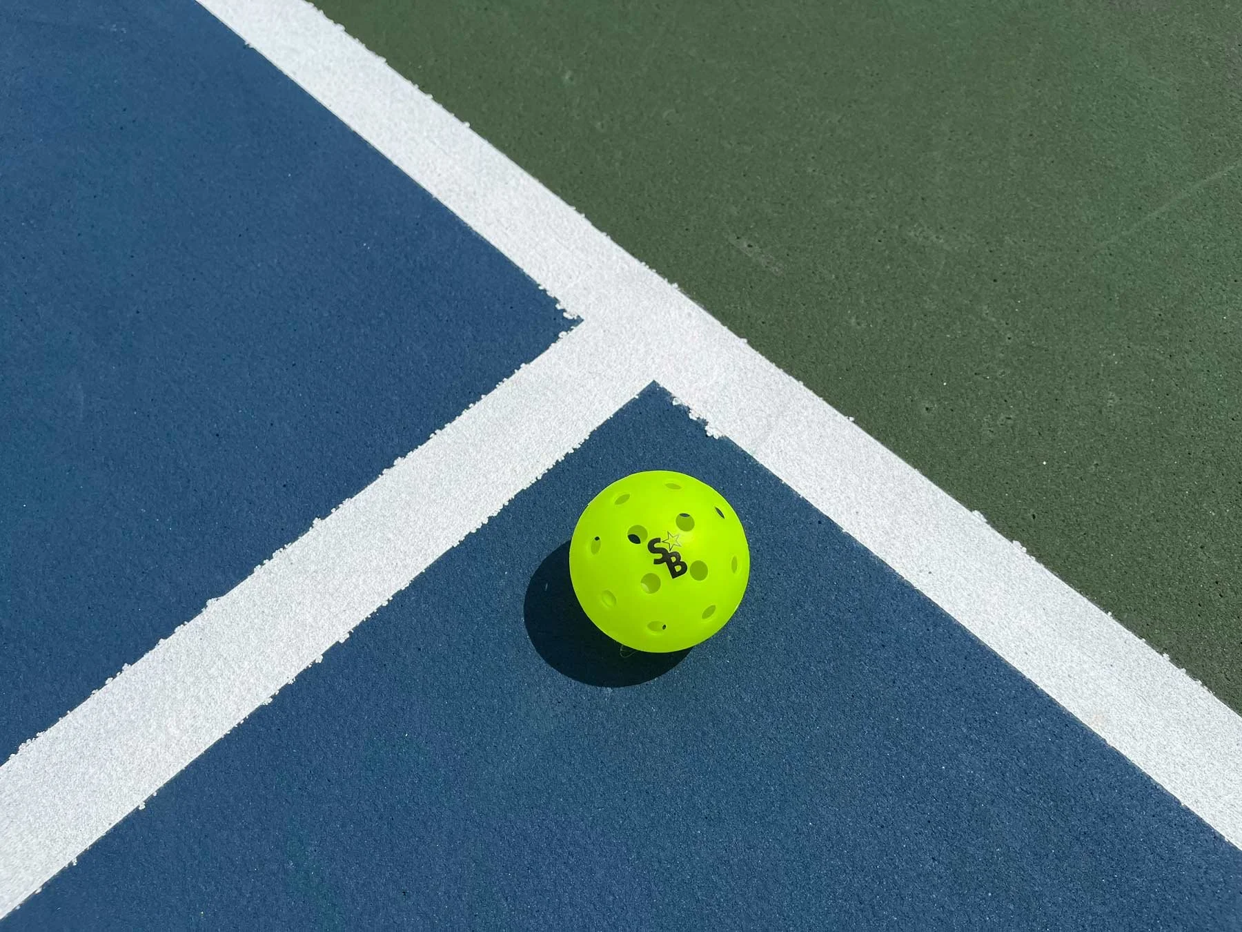 A pickleball sitting on the court