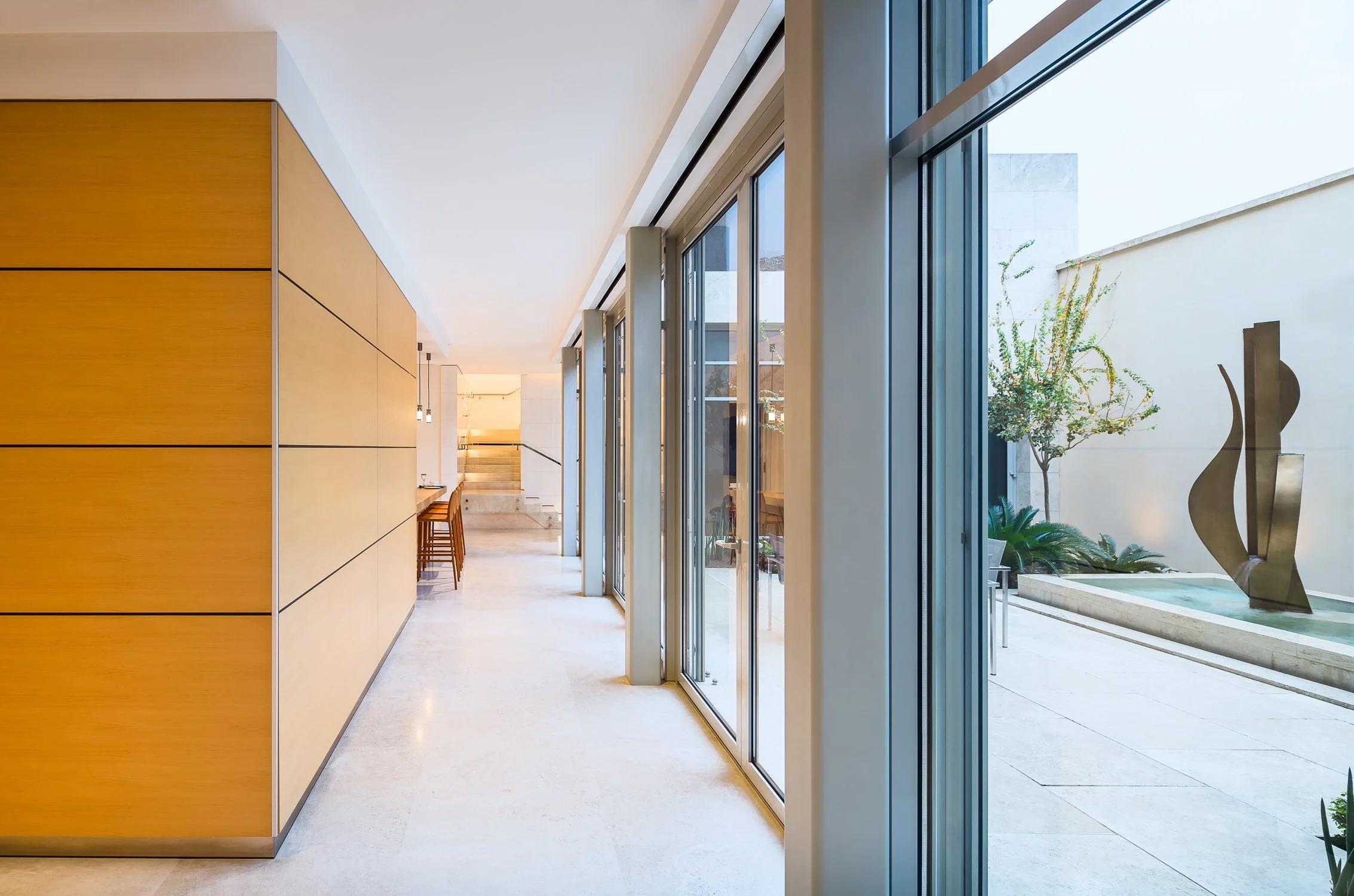 Modern hallway design with expansive windowed doorways for optimal sunlight and easy access to the exterior.