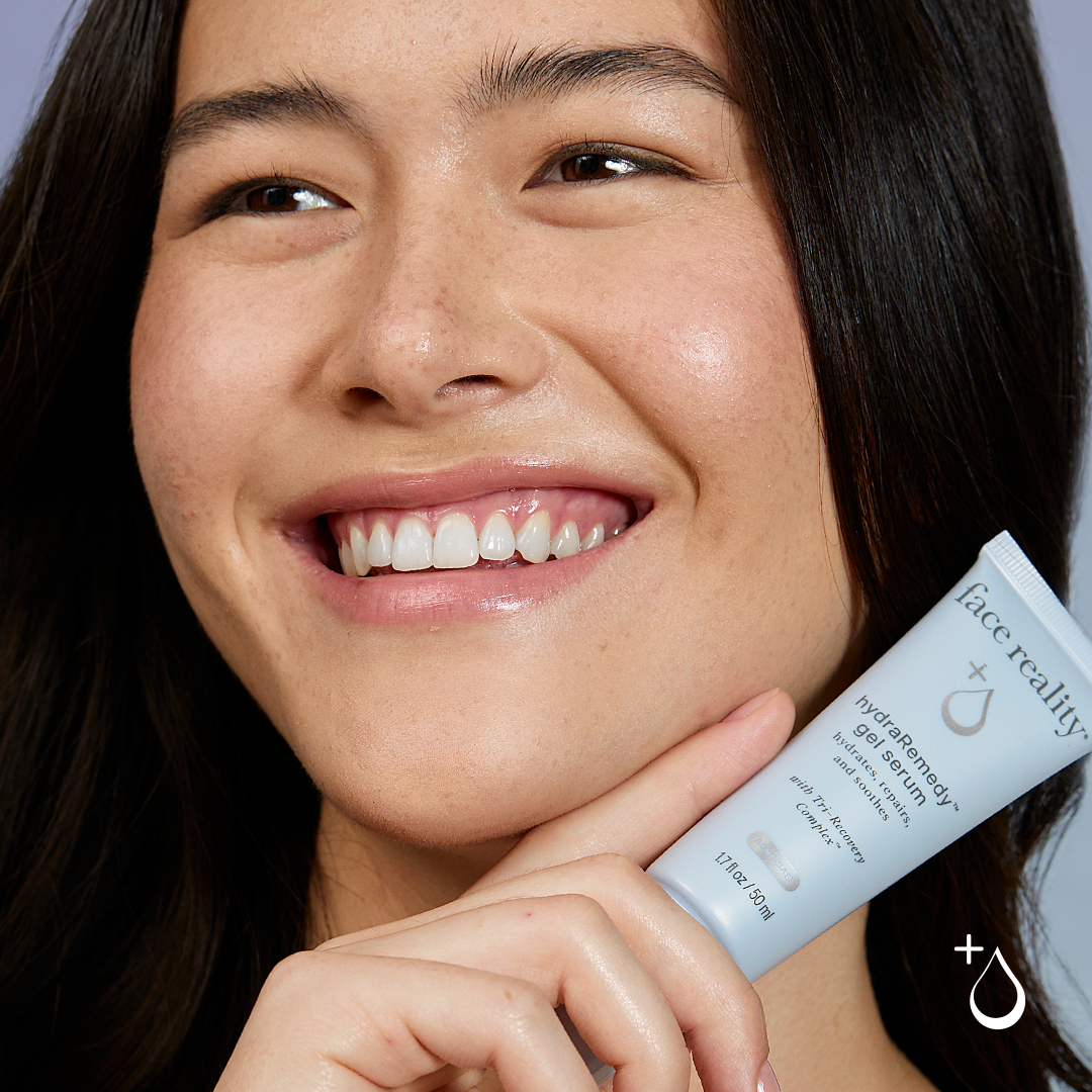 Woman smiling while holding Face Reality Skincare's HydraRemedy Gel, a professional skincare product available through Cherish Beauty Aesthetics in Waco, TX