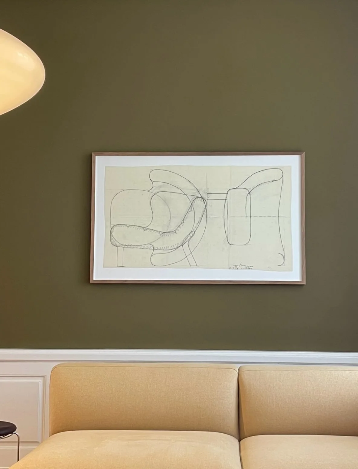 *

A space can feel both composed and intimate.

Here, the olive-green walls bring depth to the room, while the warm, textured upholstery softens the clean lines of the sofa. The white panelling introduces a more classical character, creating a subtl