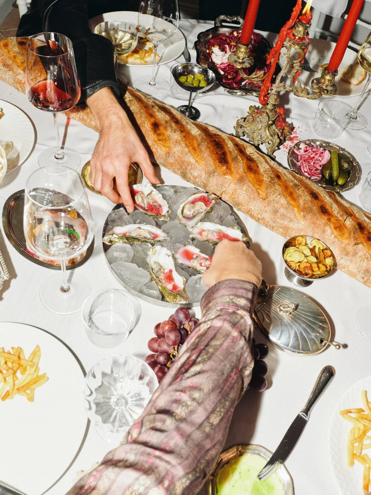 Guests gathered around an abundant dinner table with bread, wine and shared dishes at a Feast with Fiore private dining experience in Los Angeles.