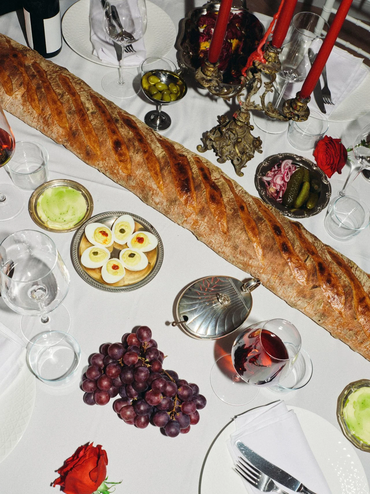 Abundant Feast with Fiore tablescape with oversized bread, grapes, deviled eggs and shared dishes in Los Angeles.