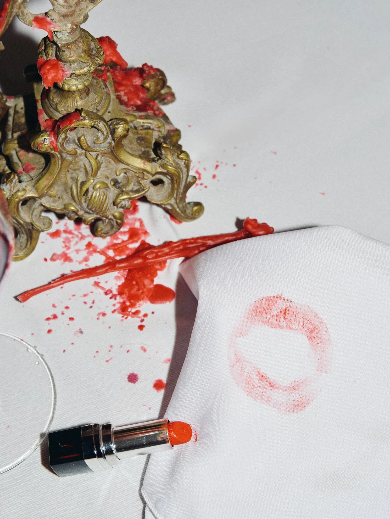 Lipstick print and red table markings beside an ornate gold place setting after a Feast with Fiore gathering.