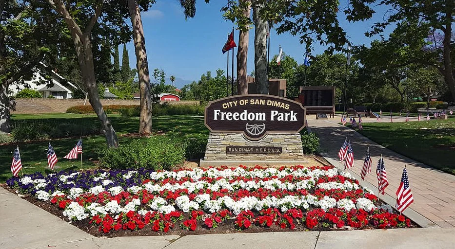 Freedom Park in San Dimas, CA. There is red, white and blue flowers with american flags around it