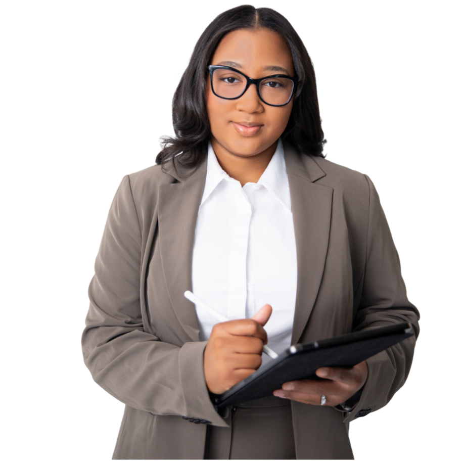 A woman wearing glasses, a beige blazer, and a white shirt standing and holding a tablet and stylus, looking at the camera.