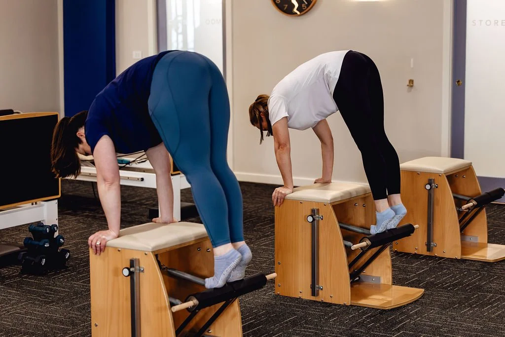 lady holding spring bar of fuse ladder Pilates studio