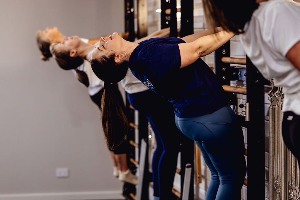3 people using the hand strap of fuse ladders in Pilates studio