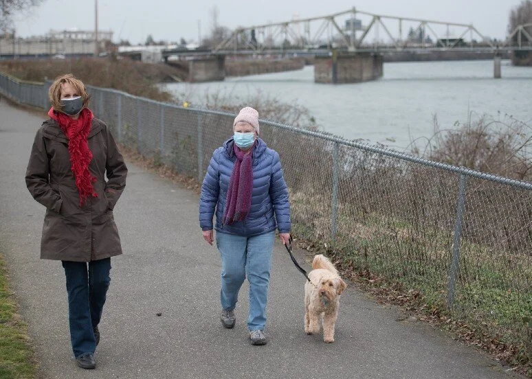 Linda, right, walks with her neighbor, Judy Fisher, on March 4, 2021 at Riverfront Park in Mount Vernon, Wash. The two grew closer during the pandemic as they were each other’s main source of in-person social interaction. In addition to walks, Linda and Judy also shared meals together outside on Linda’s deck.