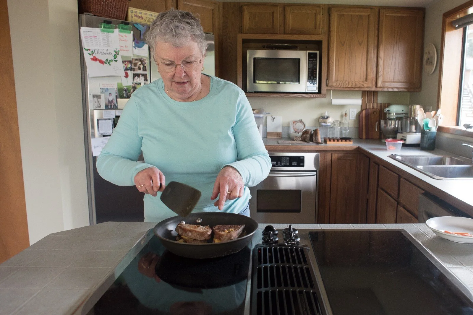Linda makes a grilled cheese with homemade sourdough bread her daughter made for Linda’s birthday in her home on March 7, 2021 in Mount Vernon, Wash.