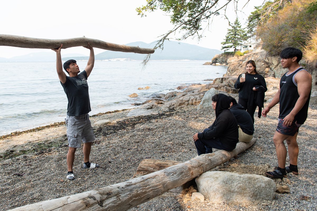  Gilberto Medrano, a student in the Skagit Valley College Summer Bridge Program, shows off his strength while hanging out with classmates on Aug. 24 during a field trip to Washington Park in Anacortes.  