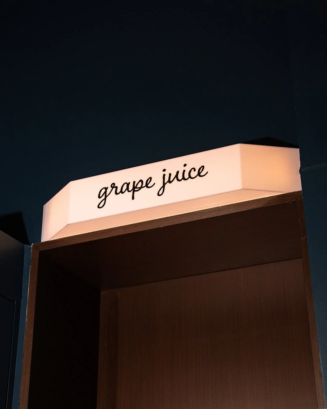 From our side: a regular old door.
From the hotel&rsquo;s side: a wooden panel that says &ldquo;Grape Juice,&rdquo; confusing half the guests who walk past it.

Is it literal? No.
Does it make sense? Also no.
Does it bother the hotel? Absolutely.
But