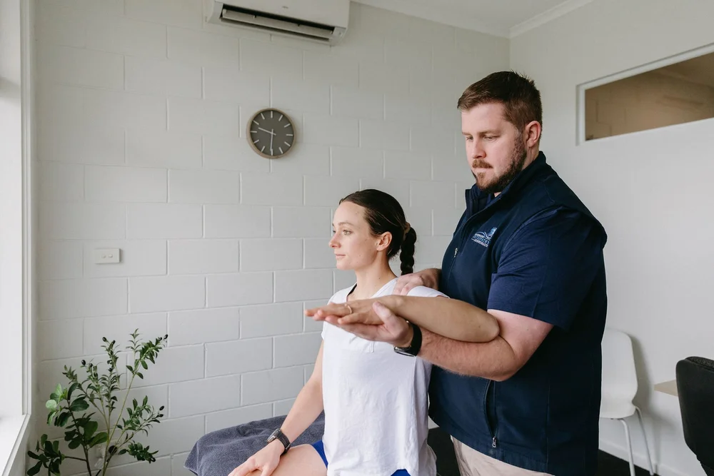 Osteopath assessing a patient's shoulder movement at OGOSH Ocean Grove