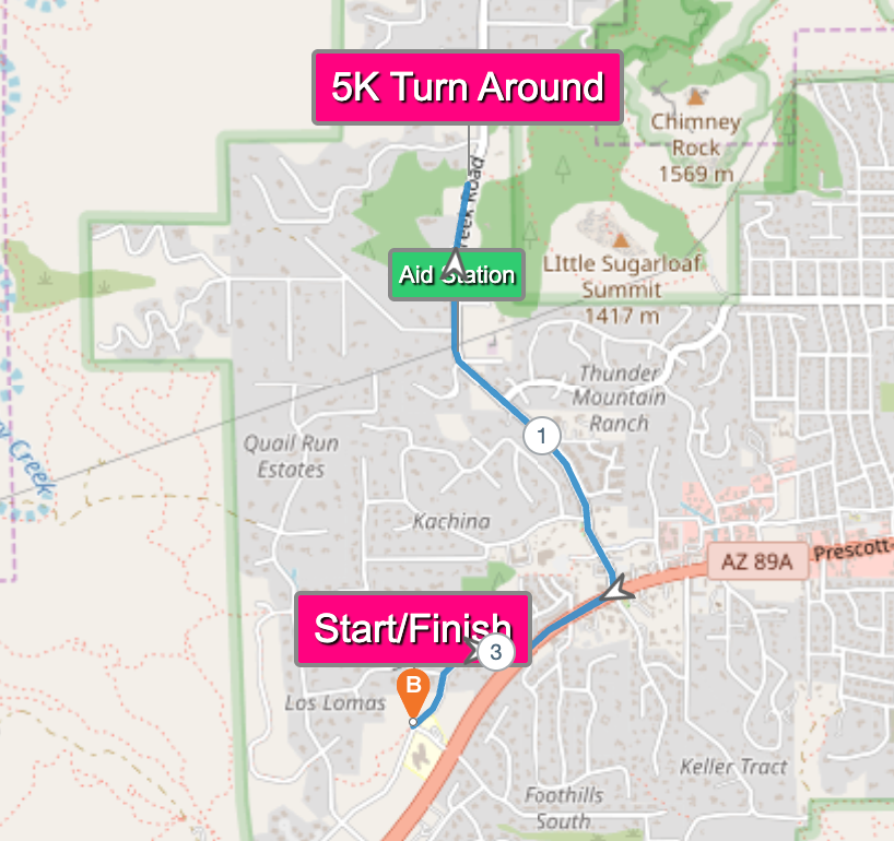 Map showing a running route for a 5K race, with the start/finish line marked near Los Lomas and a turn around point labeled 5K Turn Around, near an aid station.