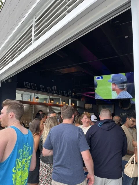 People watching a game on a large TV screen in a bar or restaurant