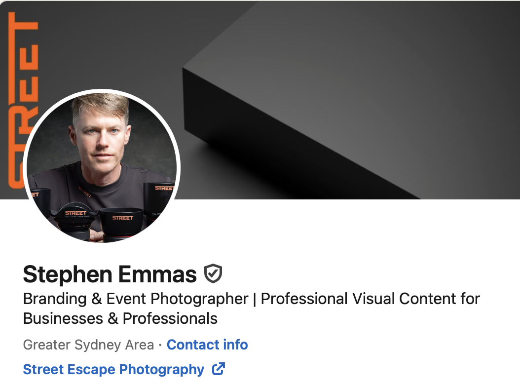 LinkedIn profile of Stephen Emmas, a branding and event photographer, with a profile picture of a man in black clothing and a background with branding materials. The banner behind him is dark gray and black.