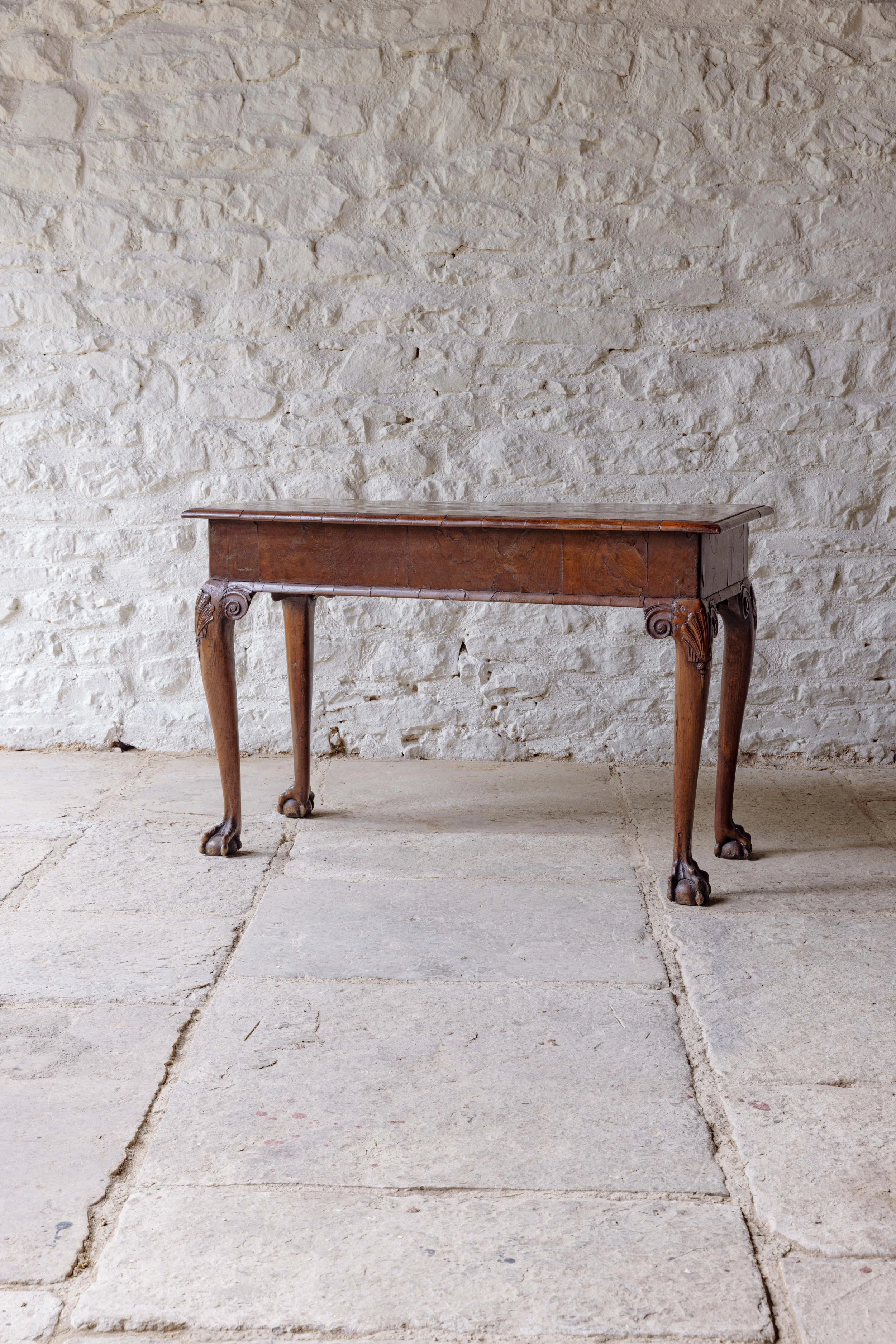 A George II walnut side table with claw feet
