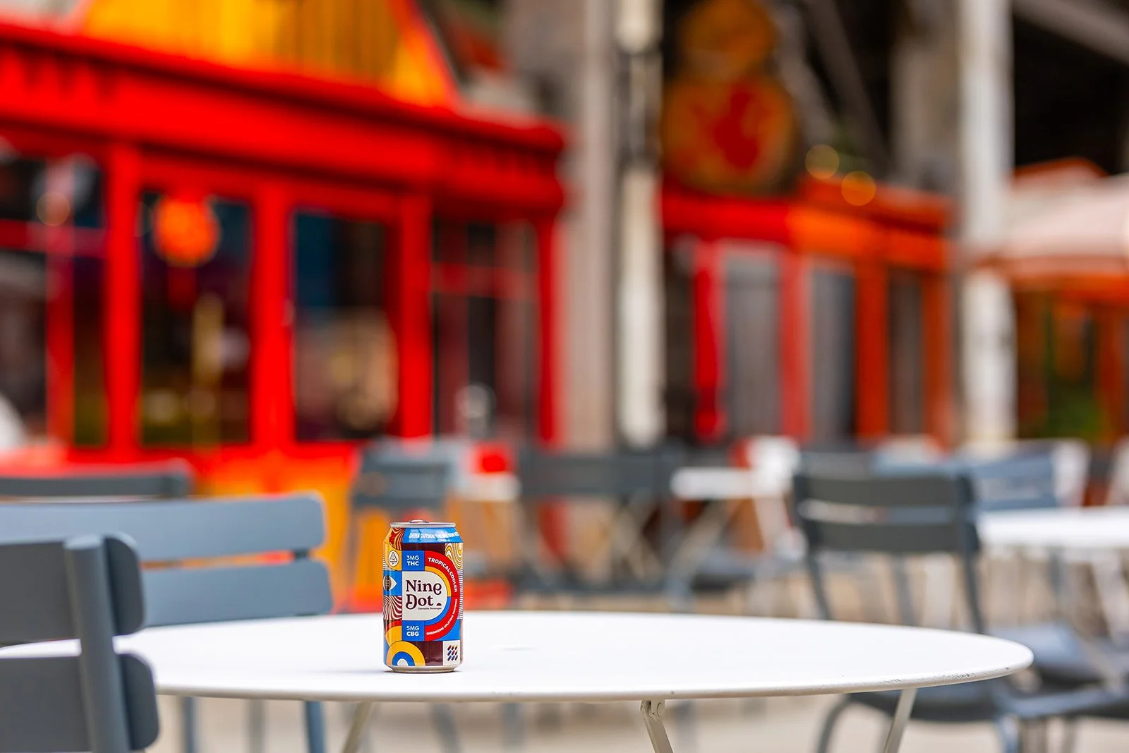 A can of Nine Dot sitting on a table outside of an urban location