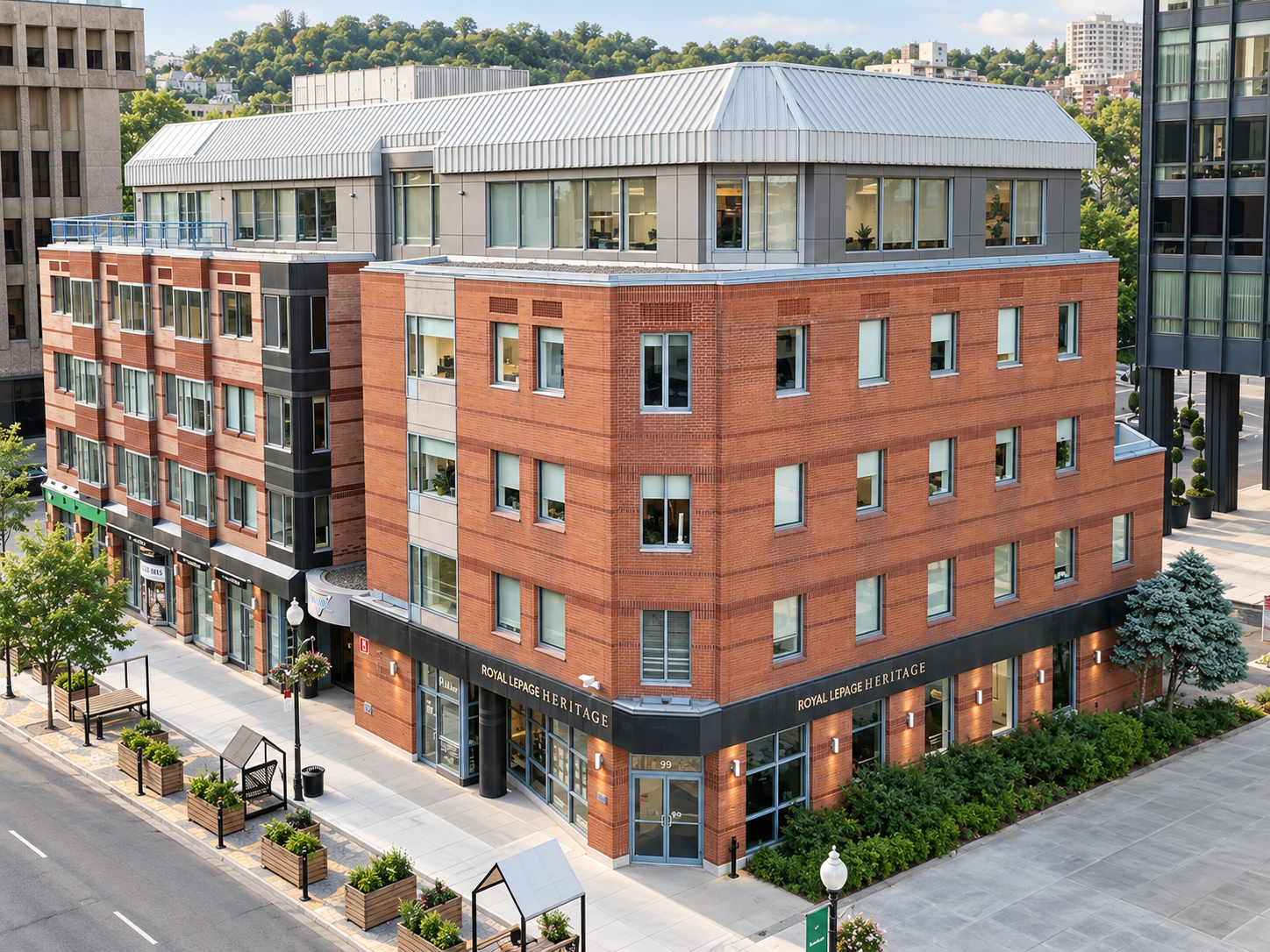 A multi-story brick building with retail stores on the ground floor and office spaces above, named Royal LePage Heritage, situated at the corner of an urban street.
