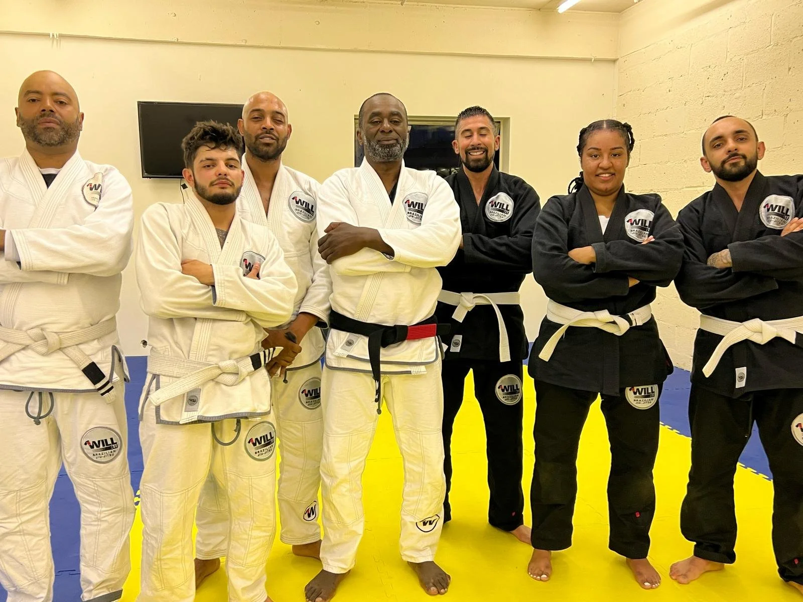 Group of martial artists in gis posing in a dojo