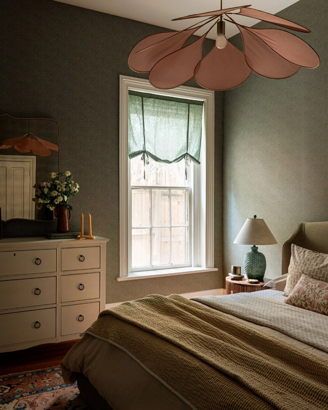 This is the kind of bedroom you don't want to leave in the morning.

The tight pattern of the wallpaper creates a textured feel that carries through every corner of the room. The petal flush mount adds a moment of softness and whimsy overhead while r