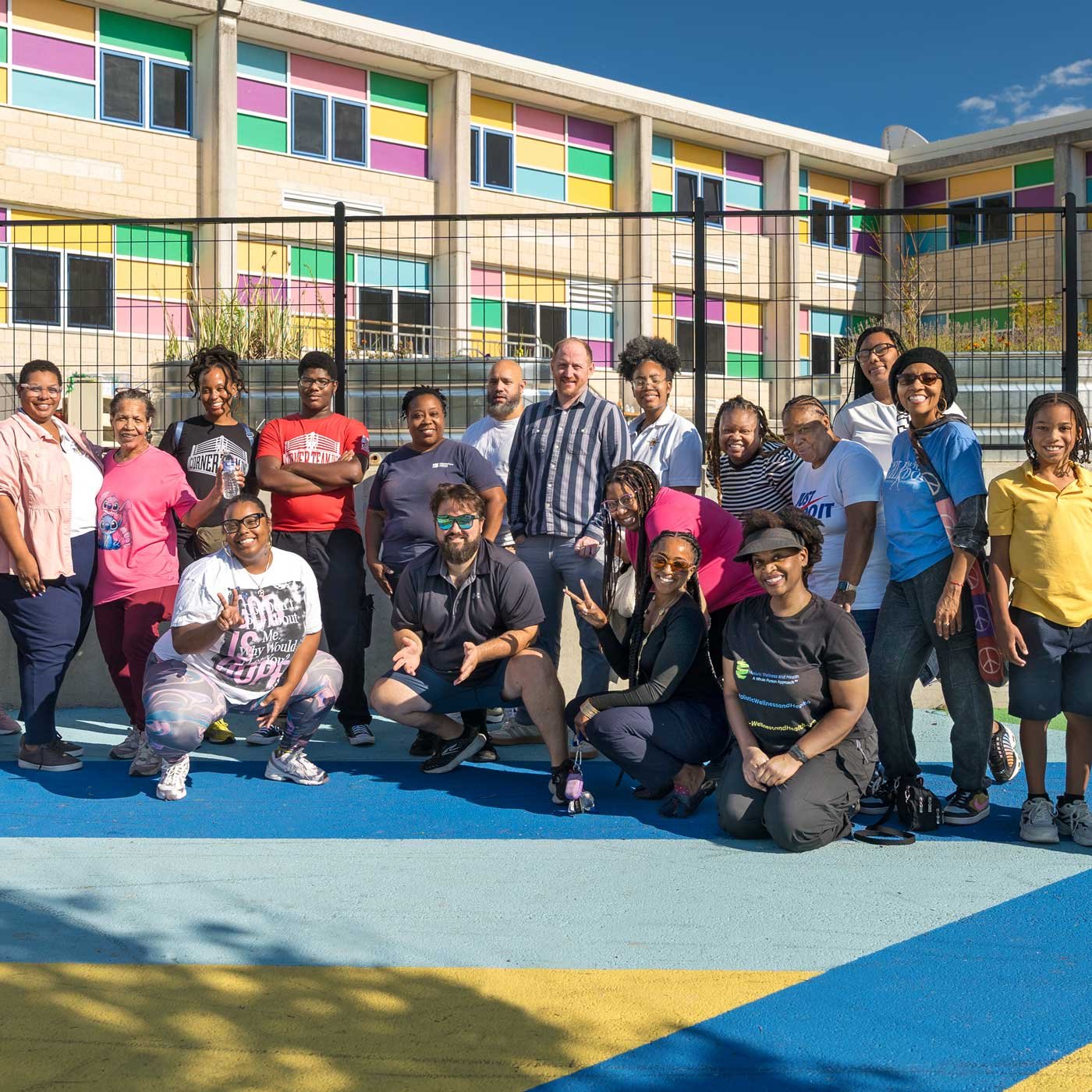 Central Baltimore community members and former Weaver Award members pose in front of a vibrant Cecil Elementary.