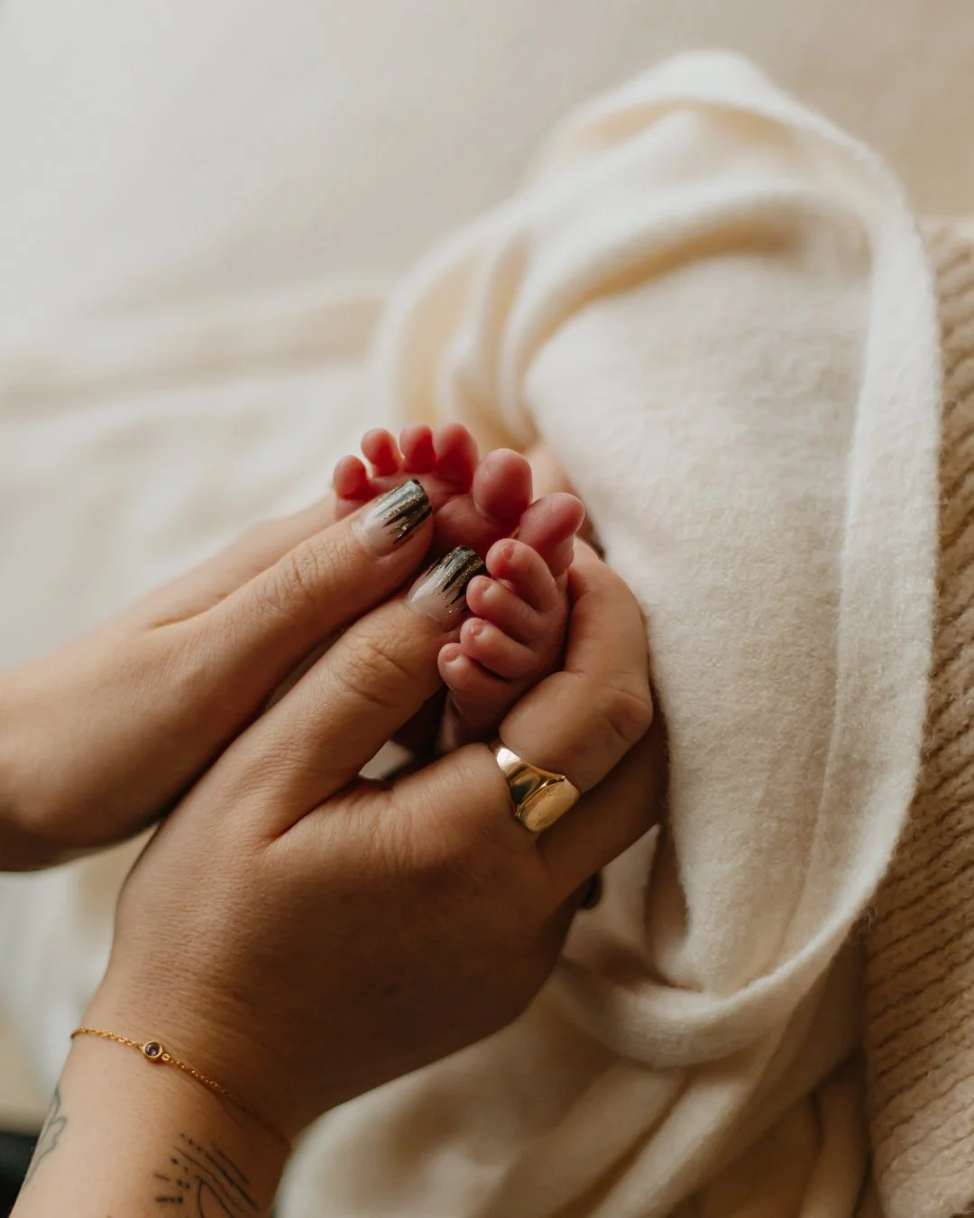 Close-up of an adult holding baby's feet.