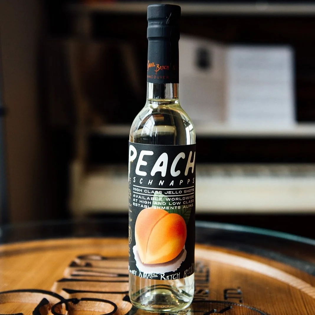 A bottle of Peach Schnapps on a wooden surface, with a blurred background.