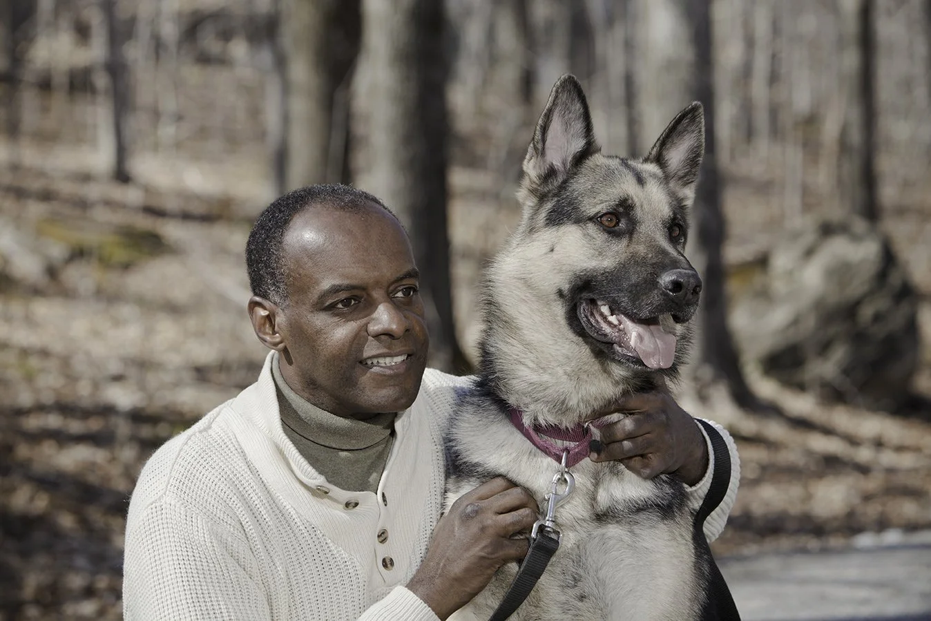 Man and his dog hiking on a trail in the fall