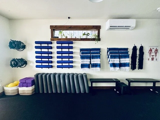 Gym, physical therapy, wellness or yoga studio with exercise equipment and wall-mounted accessories.