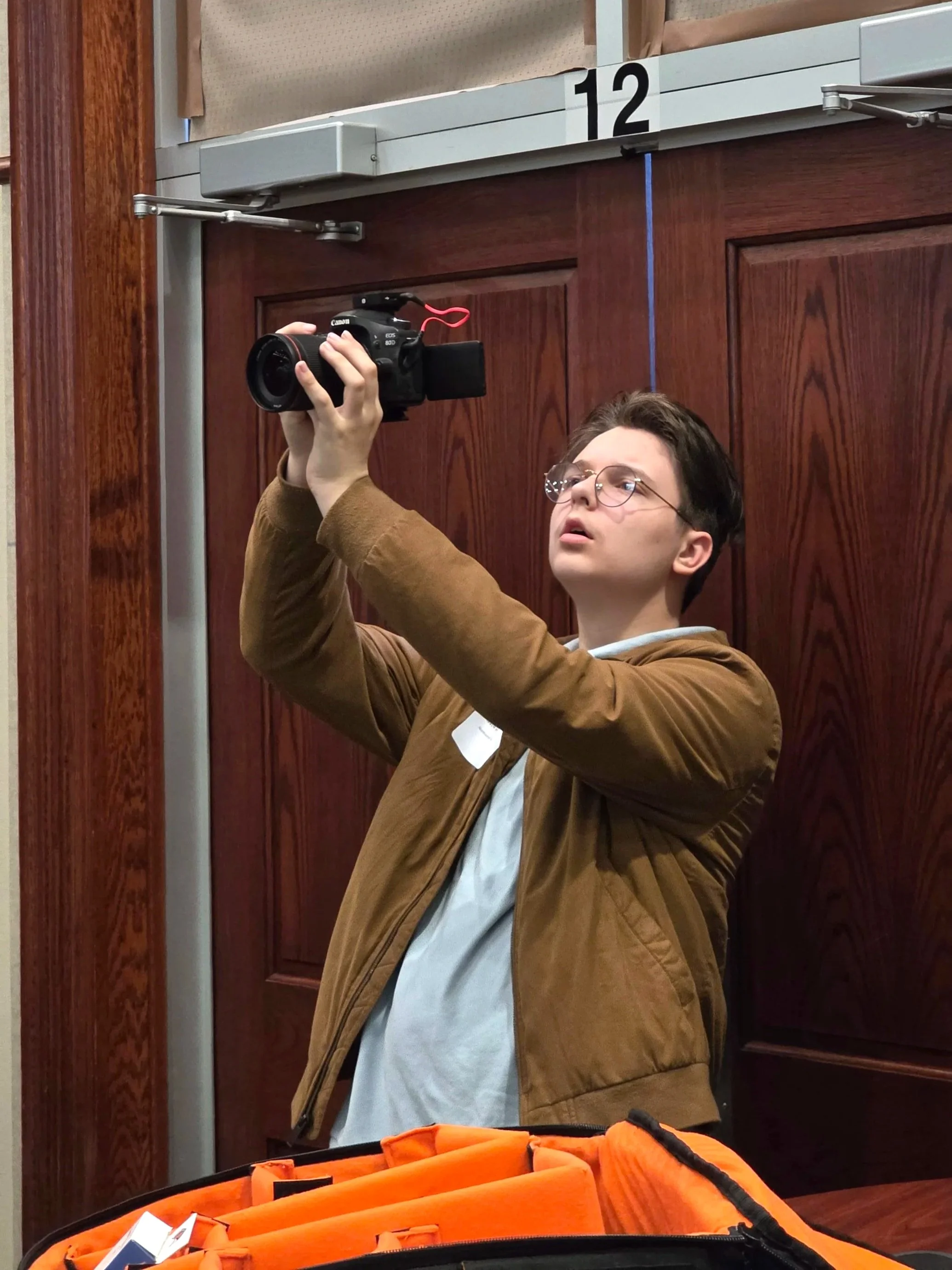 NCAPS student capturing video of a guest speaker at a professional event.