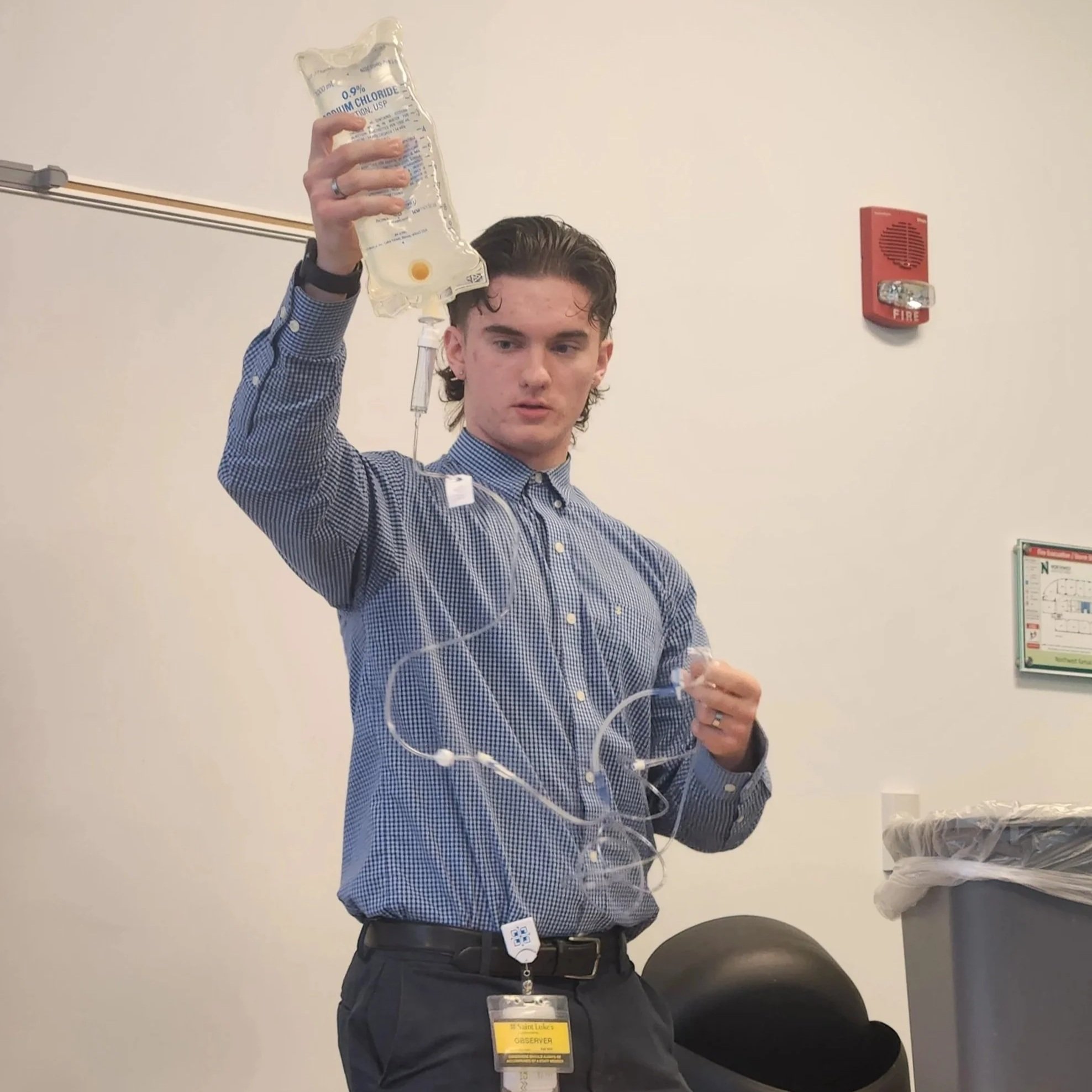 Student presents a healthcare project demonstrating proper IV drip setup techniques.