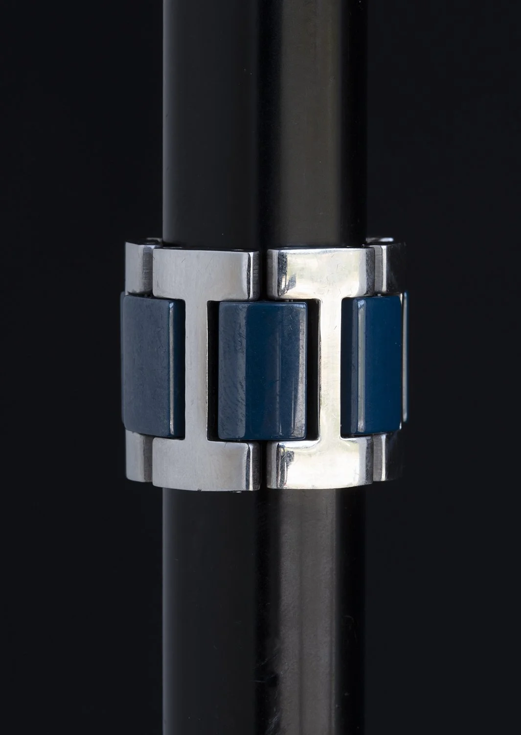 Close-up of a metallic and blue mechanical part on a black background.