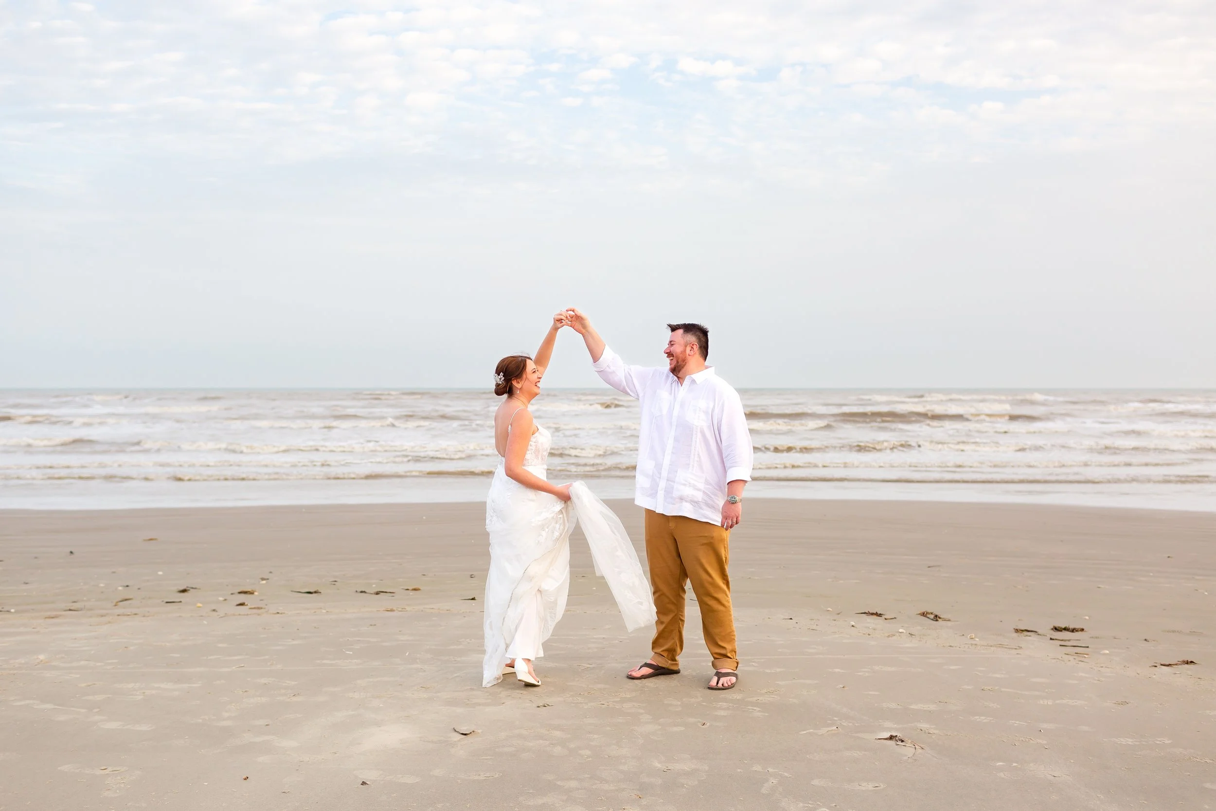Sunset portraits of newlyweds embracing along the shoreline in Galveston.
