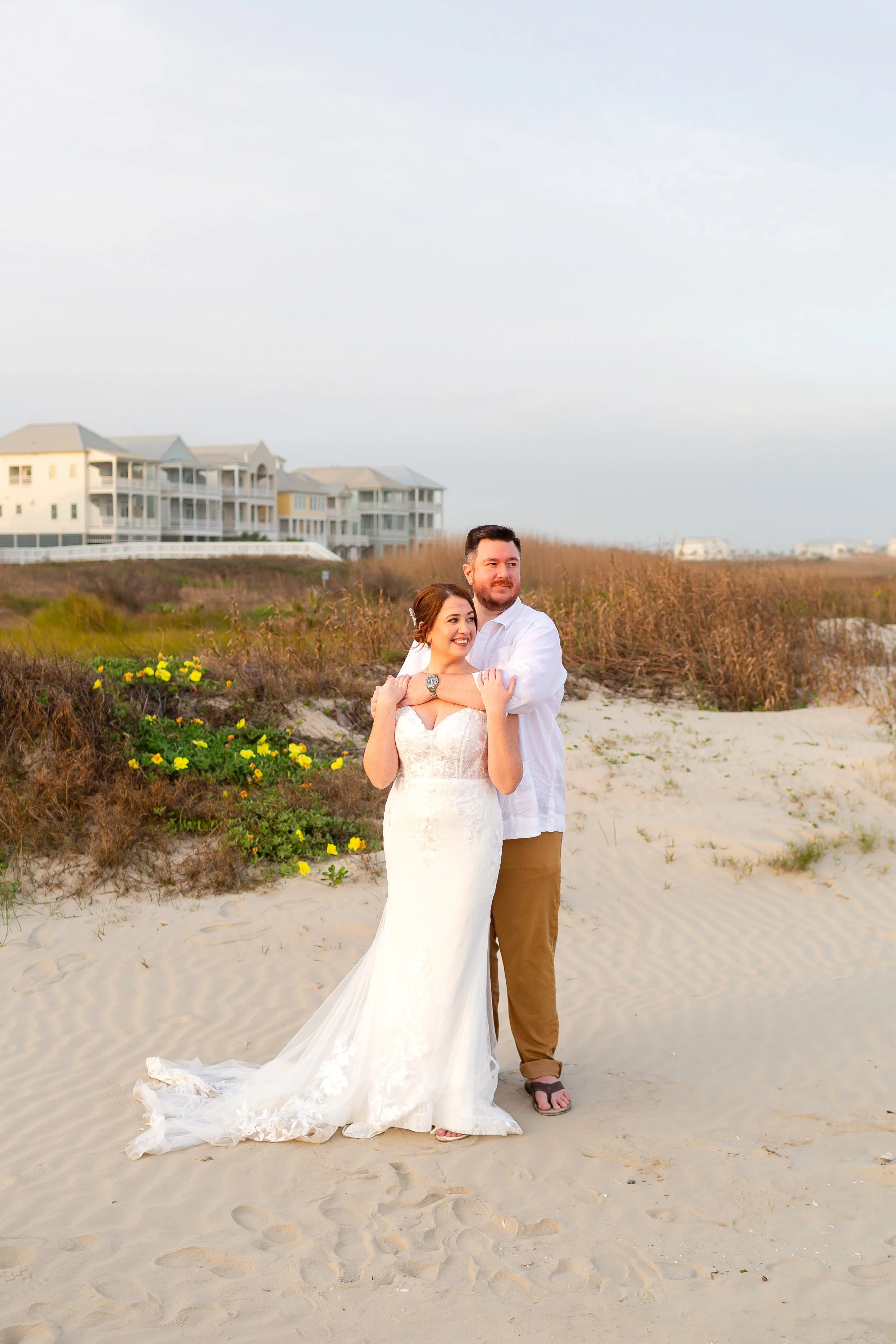 Sunset portraits of newlyweds embracing along the shoreline in Galveston.