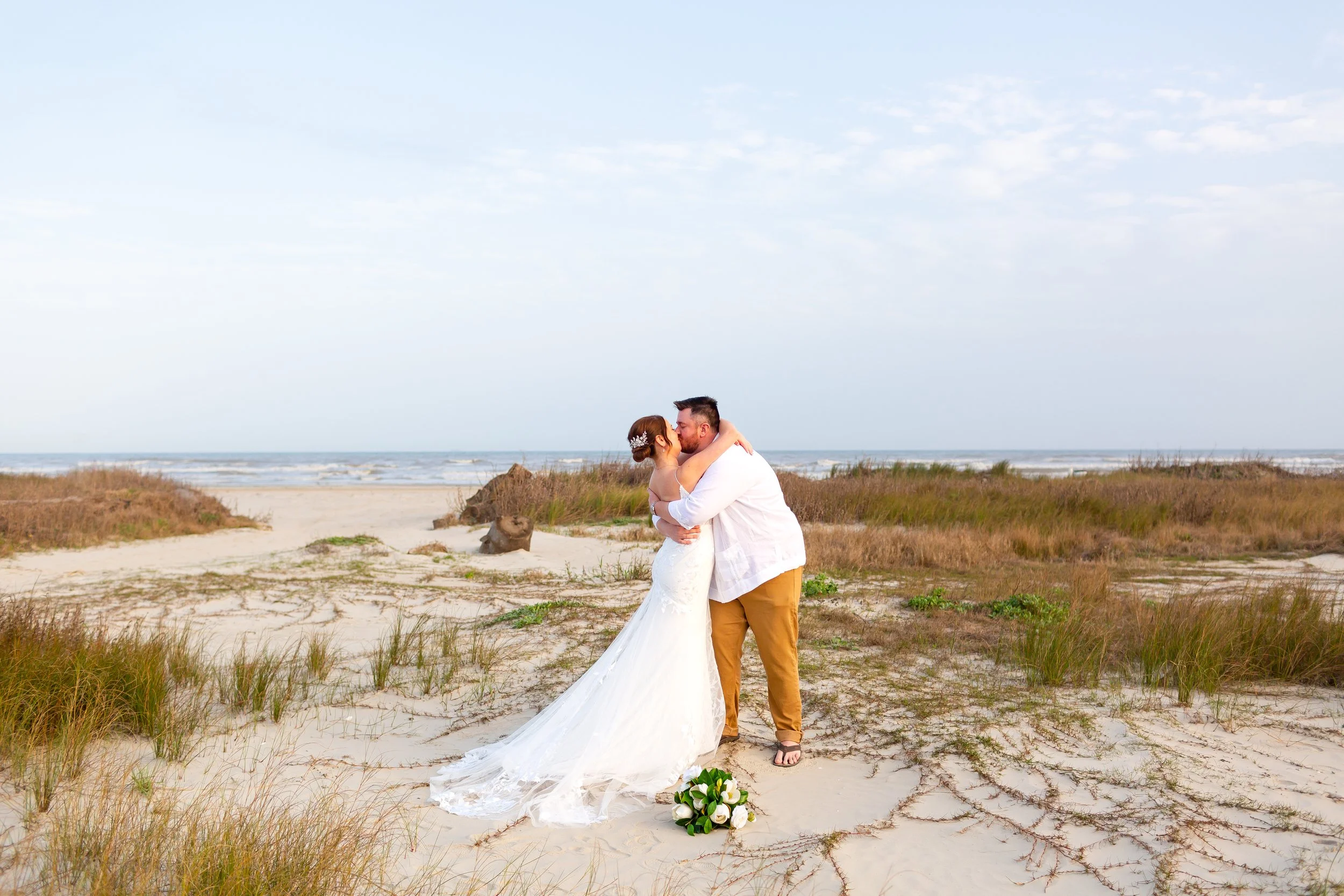 A romantic moment captured with ocean waves and golden sunlight in the background.