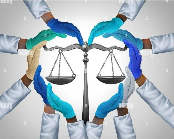 The gloved hands of medical professionals forming the shape of a heart around the scales of justice