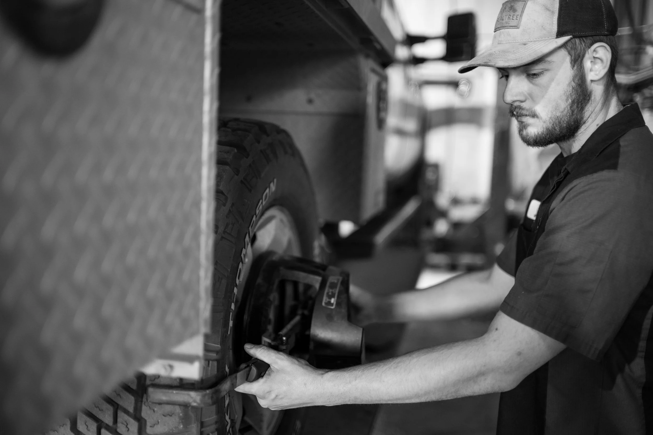 a drive on rack for aligning a car or truck sits on a concrete mechanic shop floor