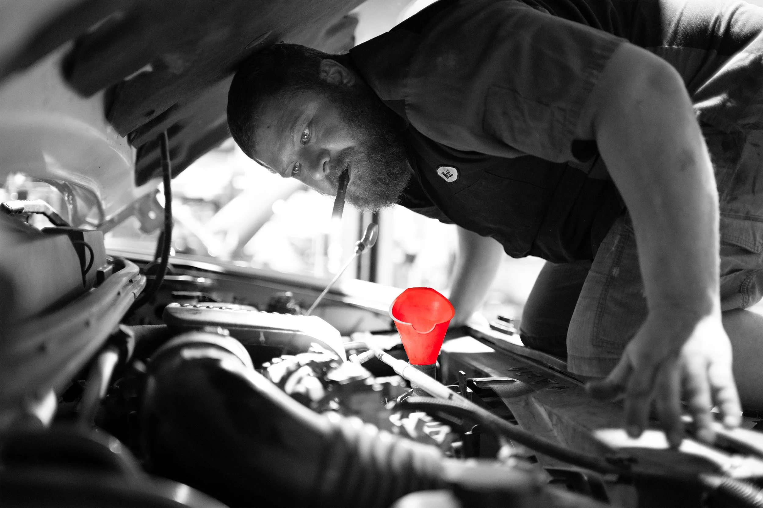 two men in dark ride rite shirts examine an engine in a classic car