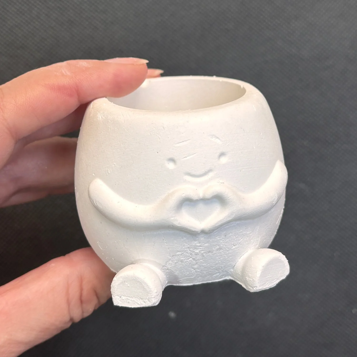 Maceta de yeso con manitas en corazón para pintar. Medidas: 5 × 6 cm.