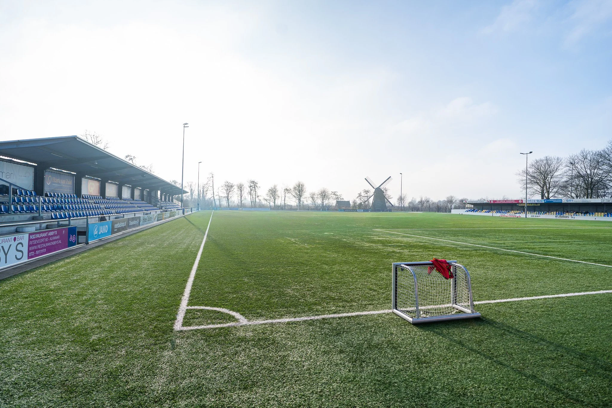 Empty soccer field with goalpost and windmill in the background