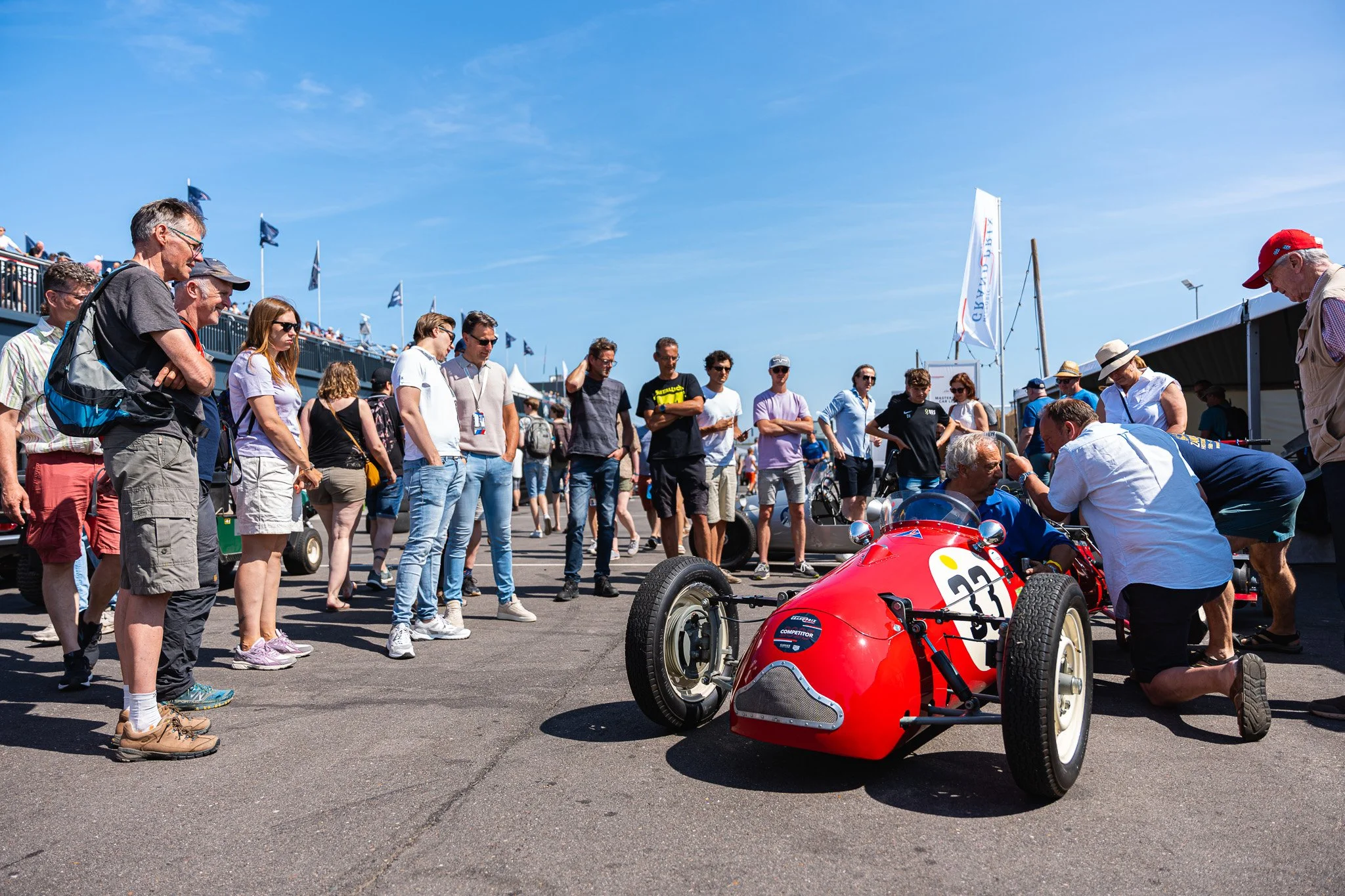 Mensen kijken naar een raceauto op een race-evenement op een zonnige dag.