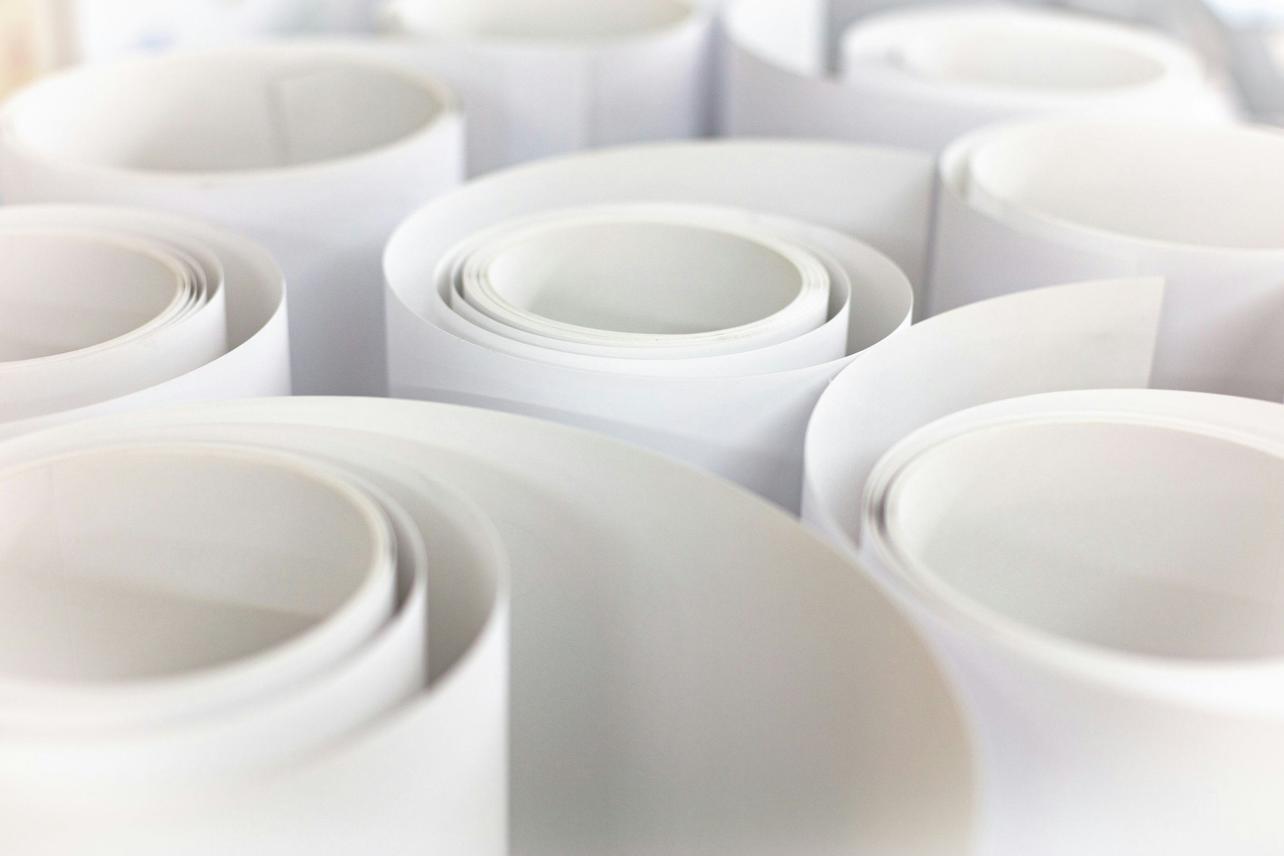 Several rolls of white paper or material stacked together.
