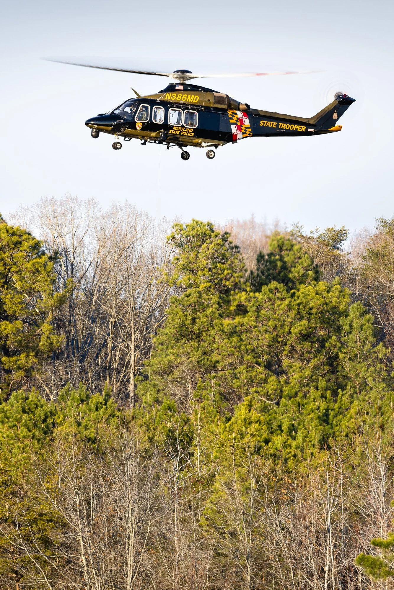 Leonardo AW139 (N386MD), callsign Trooper 7, operated by the Maryland State Police Aviation Command (MSPAC), executing hoist training at St. Mary’s County Regional Airport (2W6) on a crisp winter afternoon.