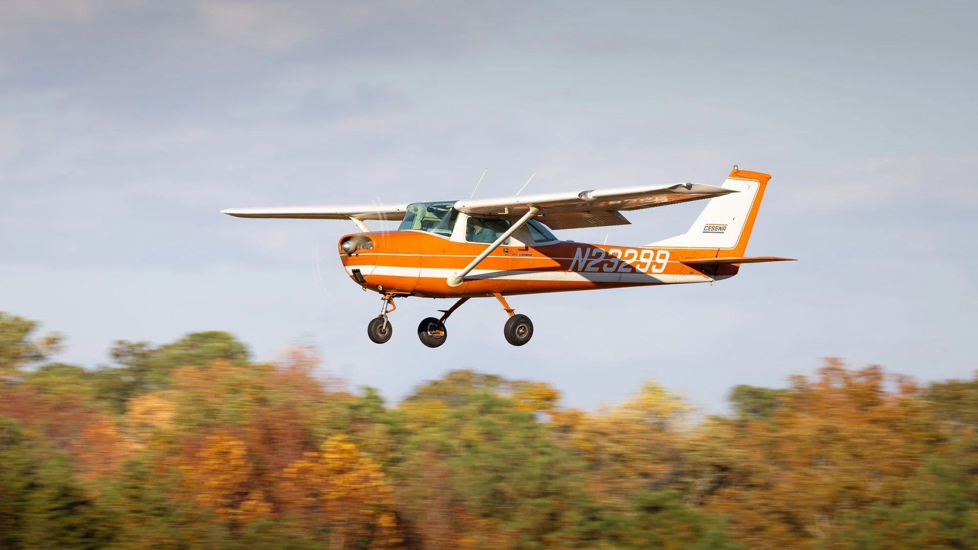 Cessna 150H (N23299) landing at St. Mary's County Regional Airport (2W6) with some beautiful fall foliage in the background. 