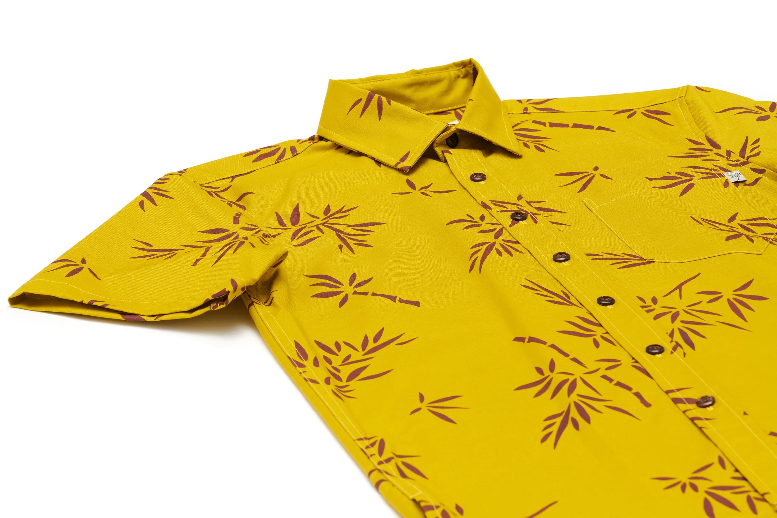 Yellow short-sleeve button-up shirt with a brown leaf-like pattern.
