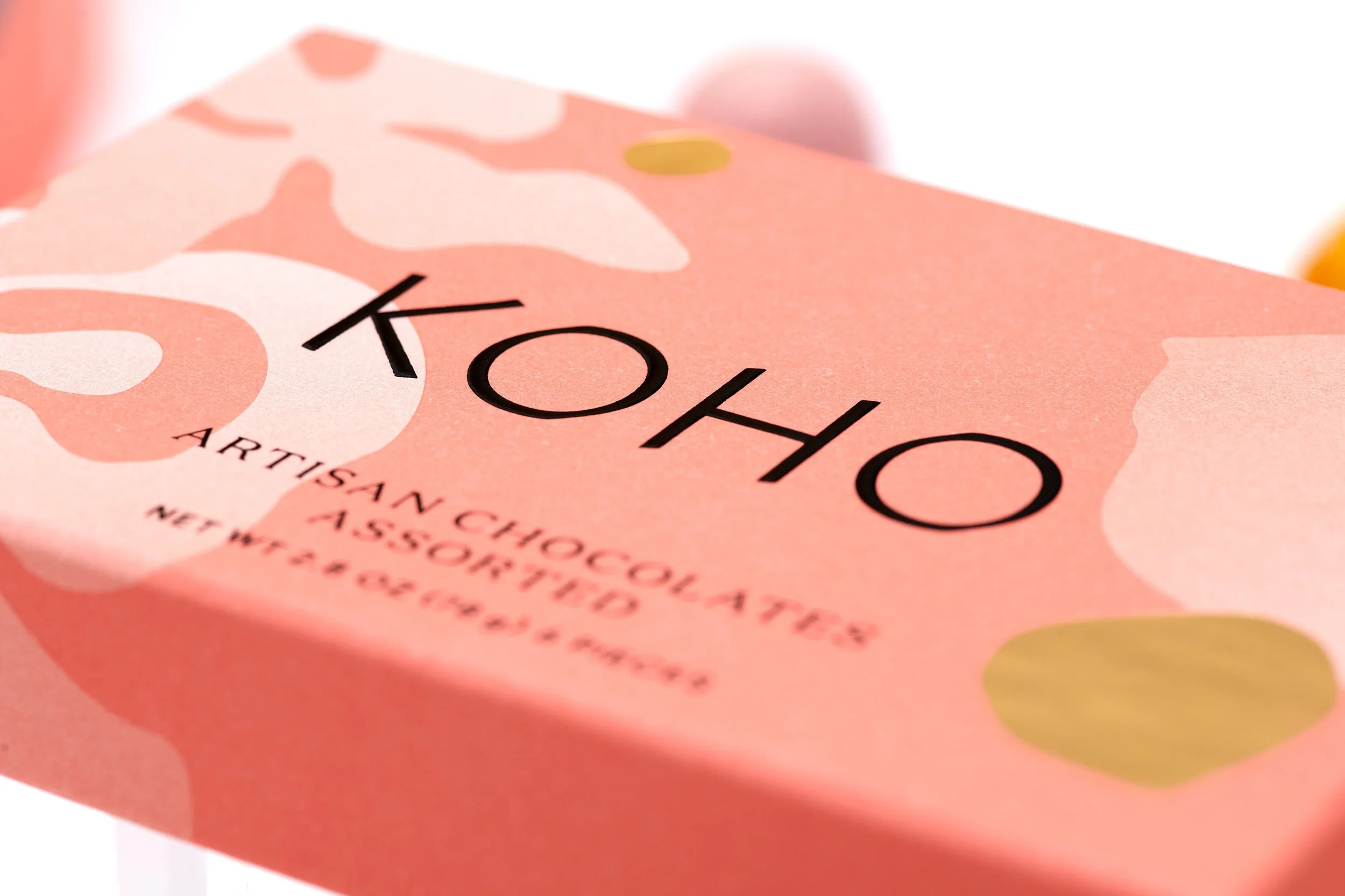 Close-up of a pink Kahlo chocolate bar wrapper with black text and gold accents.