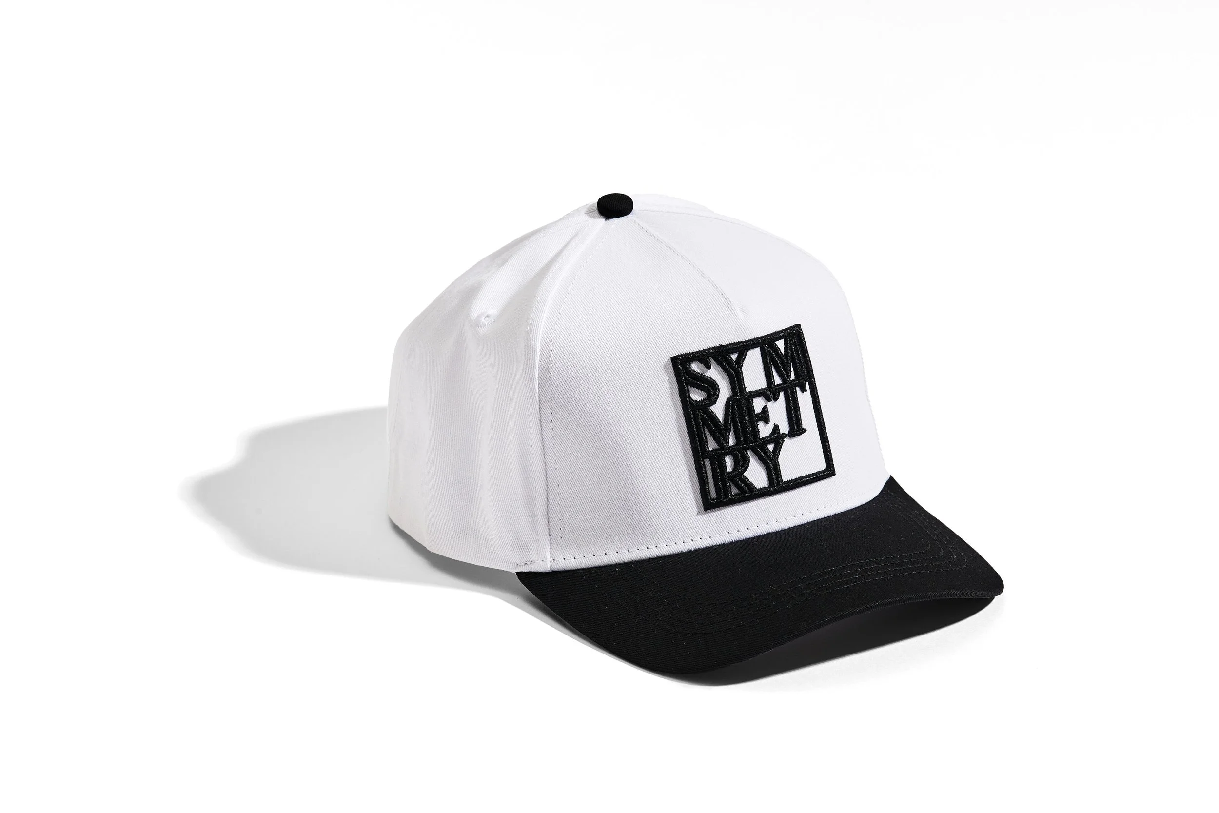 white and black baseball cap with the word 'STAY REACTIVE' embroidered on the front in black letters.