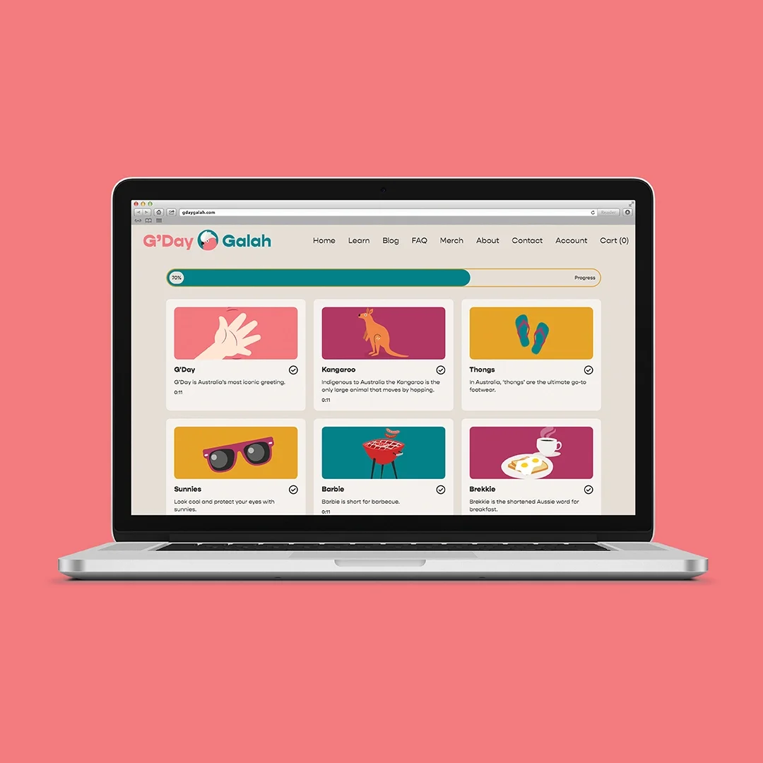 A laptop on a pink background displaying a webpage with colorful illustrations of a hand, kangaroo, flip-flops, sunglasses, barbecue grill, and breakfast items.