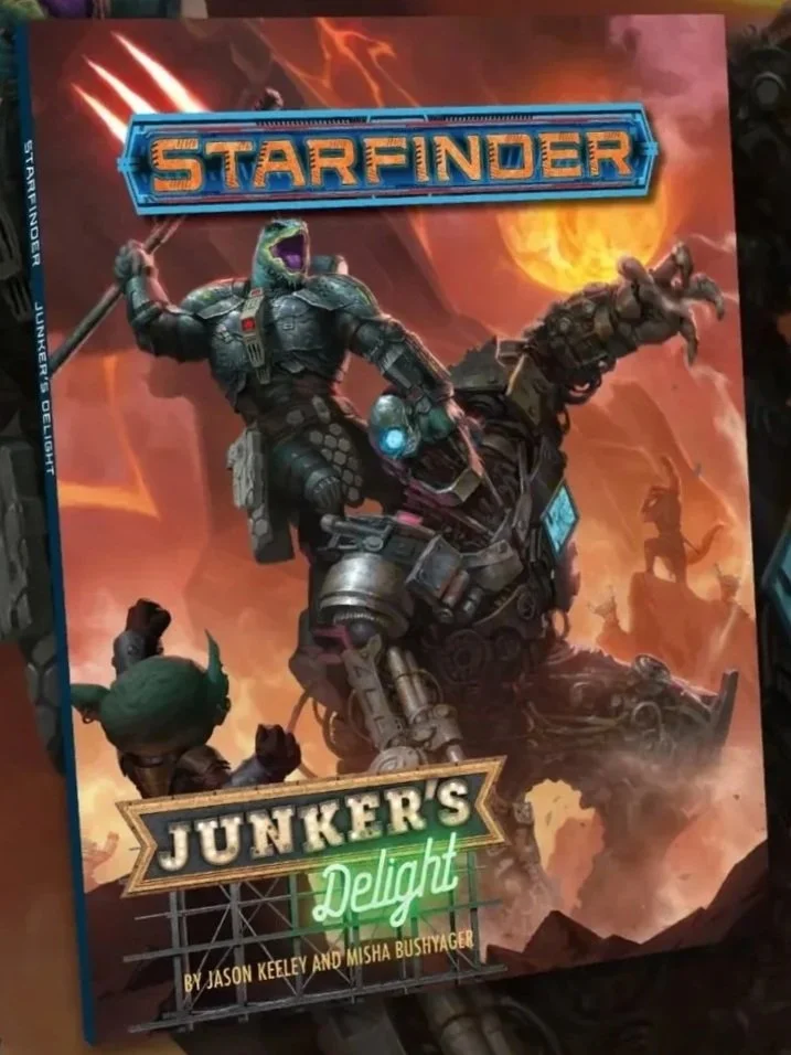 Cover of a Starfinder Adventure One Shot by Paizo entitled Junker's Delight.ting a large, monstrous humanoid creature with red eyes and an open mouth in a forest setting.